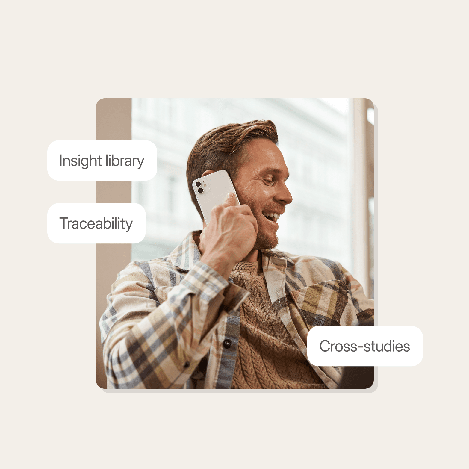 "Man smiling while on a phone call, wearing a plaid shirt over a knit sweater, with three floating labels reading Insight Library, Traceability, and Cross-studies"