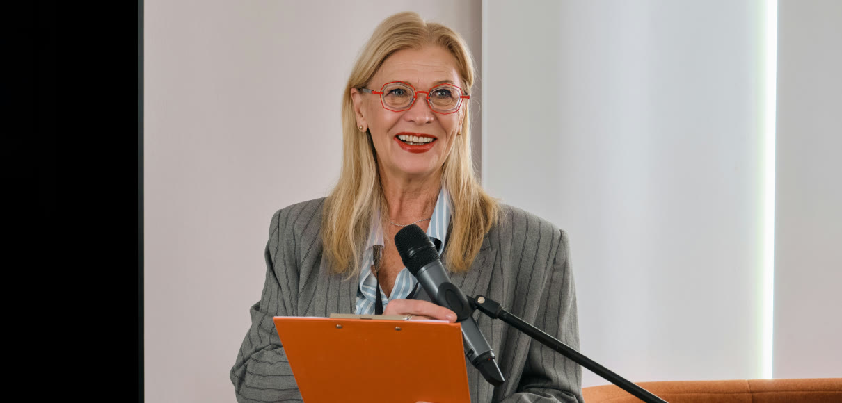 A research operations lead presenting at a lectern