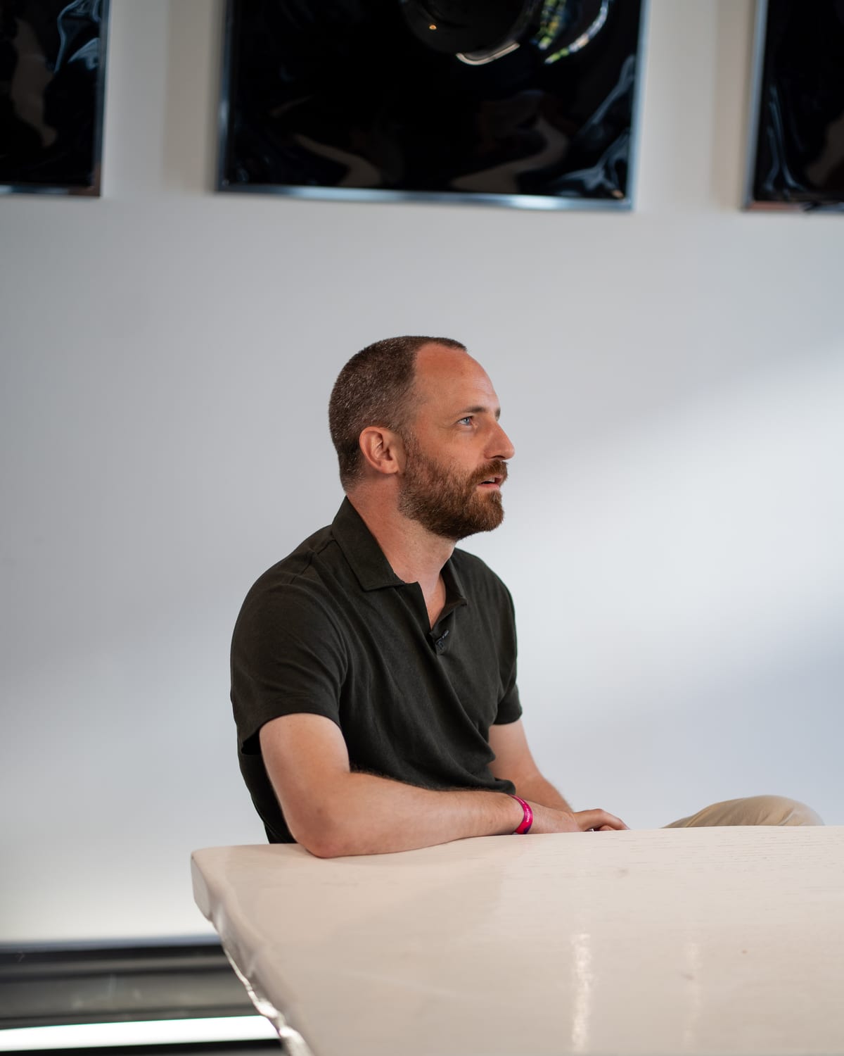 Maarten Claes in a dark polo seated at the white table on the Conveo podcast set at Cannes Lions 2026.