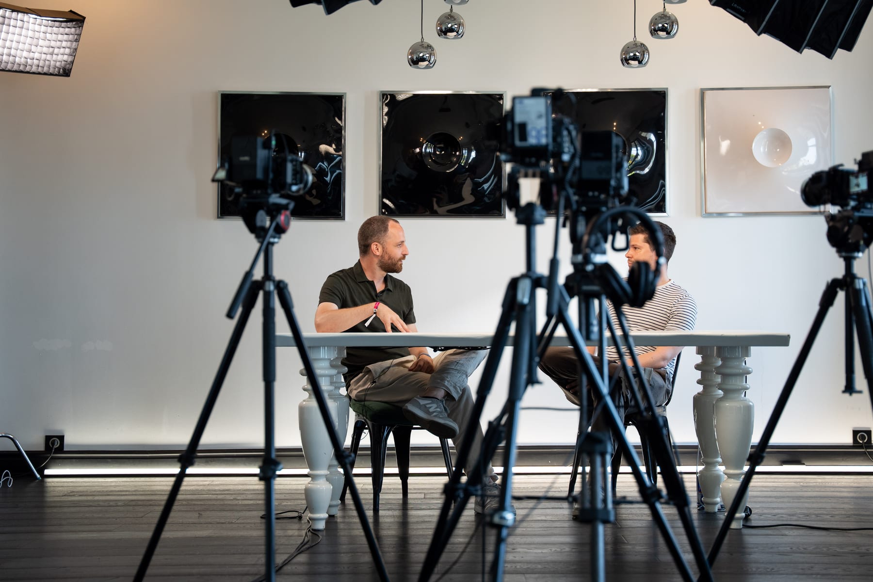 Cameras on tripods frame Maarten Claes and Dieter De Mesmaeker at the table under studio lights at Cannes Lions 2026.
