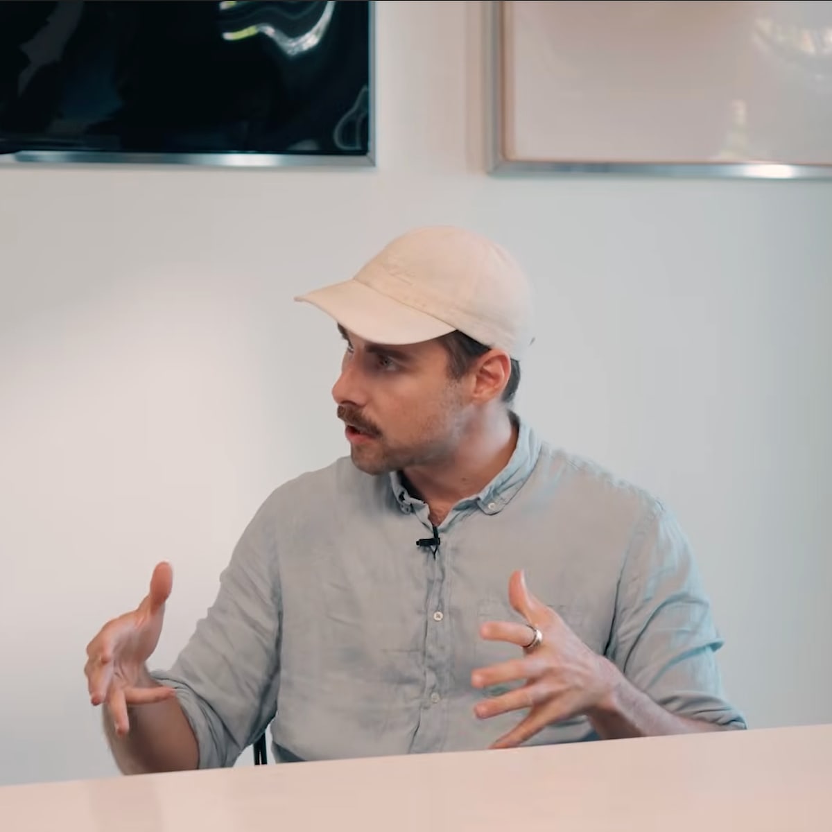 Tom Husson in a cap and linen shirt talking on the Conveo podcast set at Cannes Lions 2026