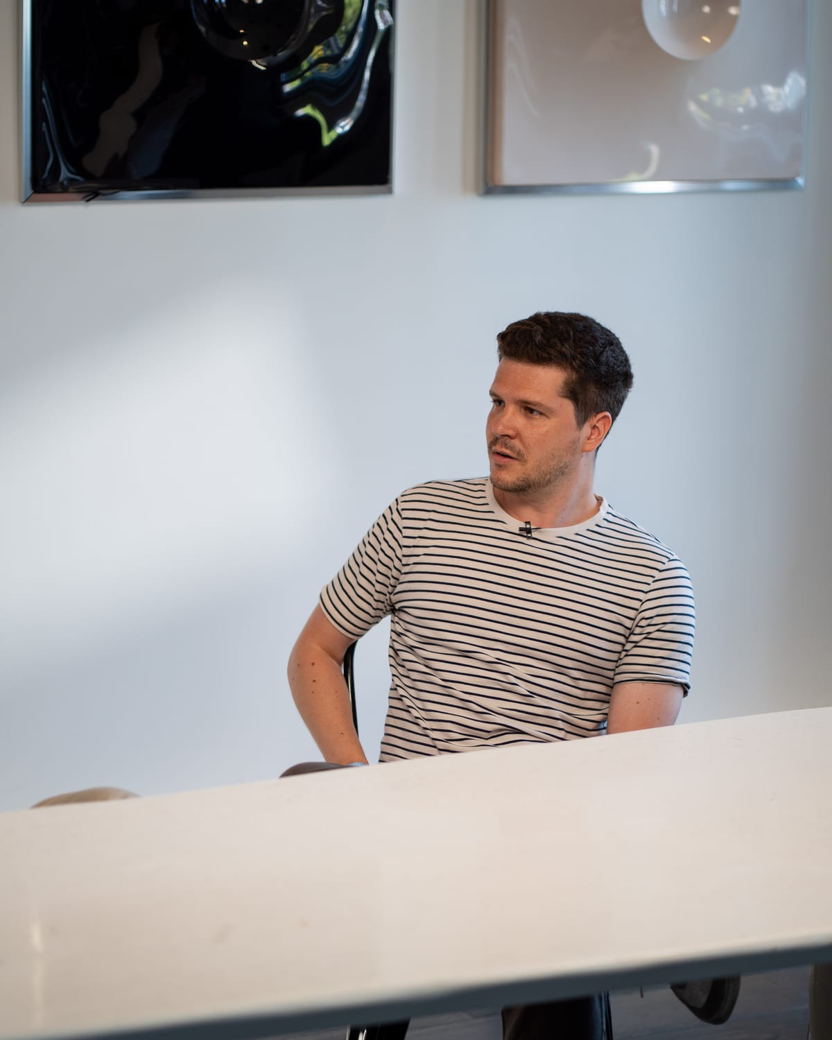 Dieter De Mesmaeker in a striped T-shirt seated at the white table on the Conveo podcast set at Cannes Lions 2026.