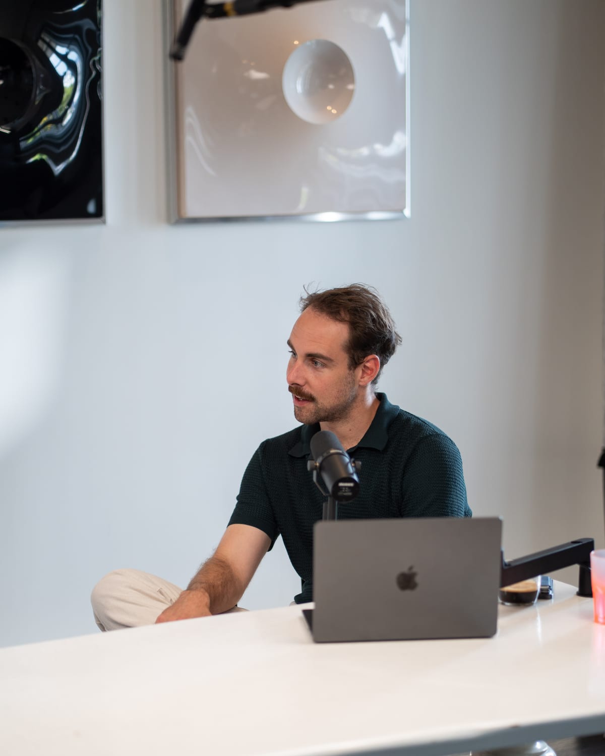 Host Tom Husson leaning on the table behind his laptop as he follows the conversation on the Conveo podcast set at Cannes Lions 2026