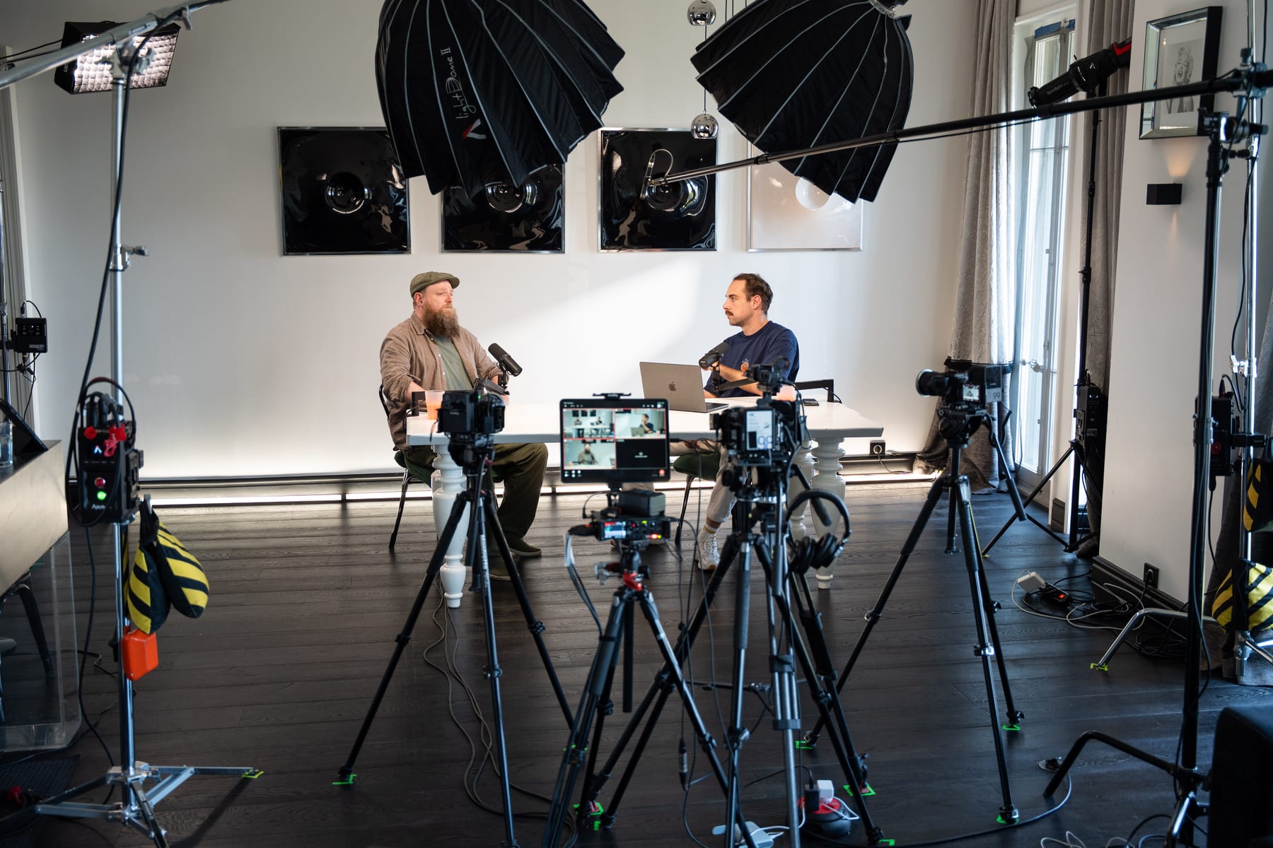 Wide view of the Conveo podcast studio with lights, tripods and cameras surrounding Wesley ter Haar and the host at a white table at Cannes Lions 2026