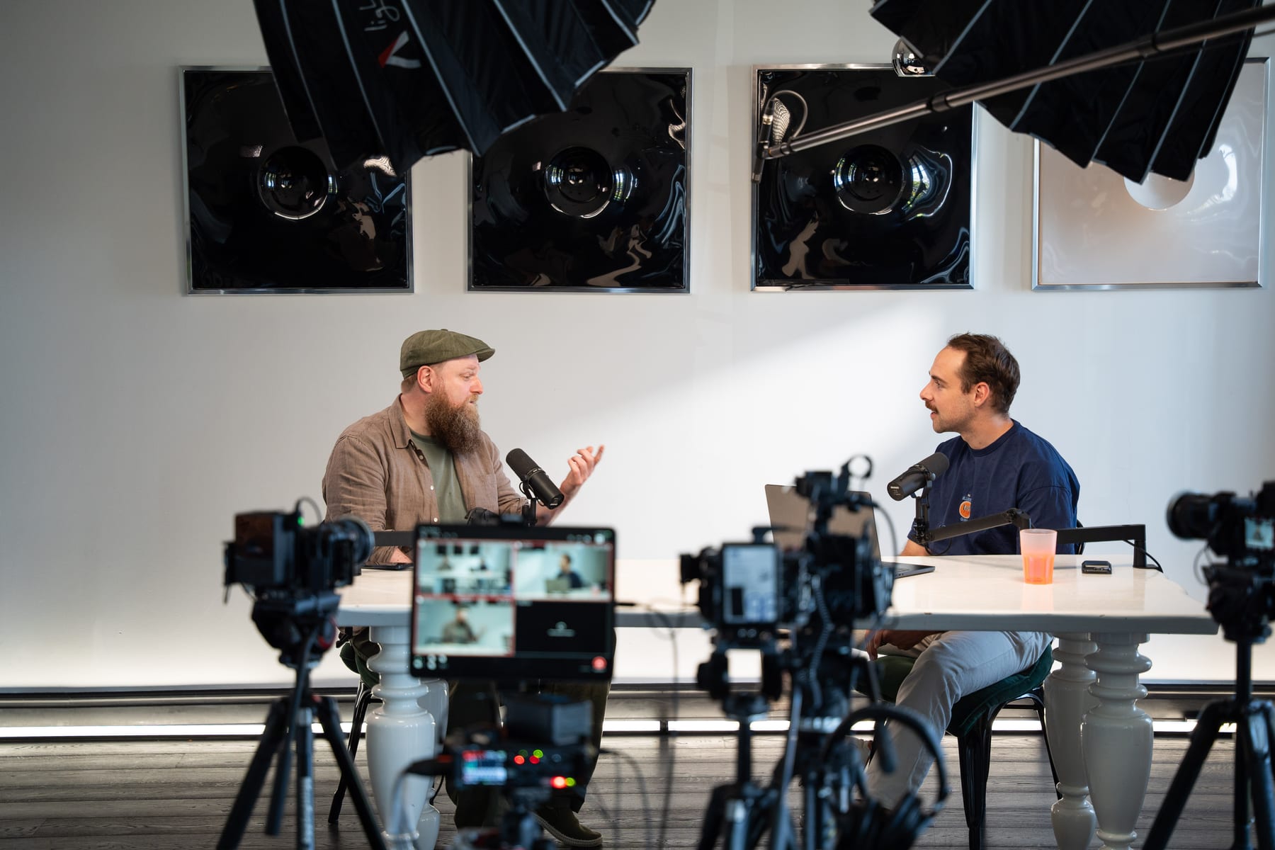 Wesley ter Haar gestures mid-sentence as the host faces him across the table, framed by cameras and a monitor at Cannes Lions 2026