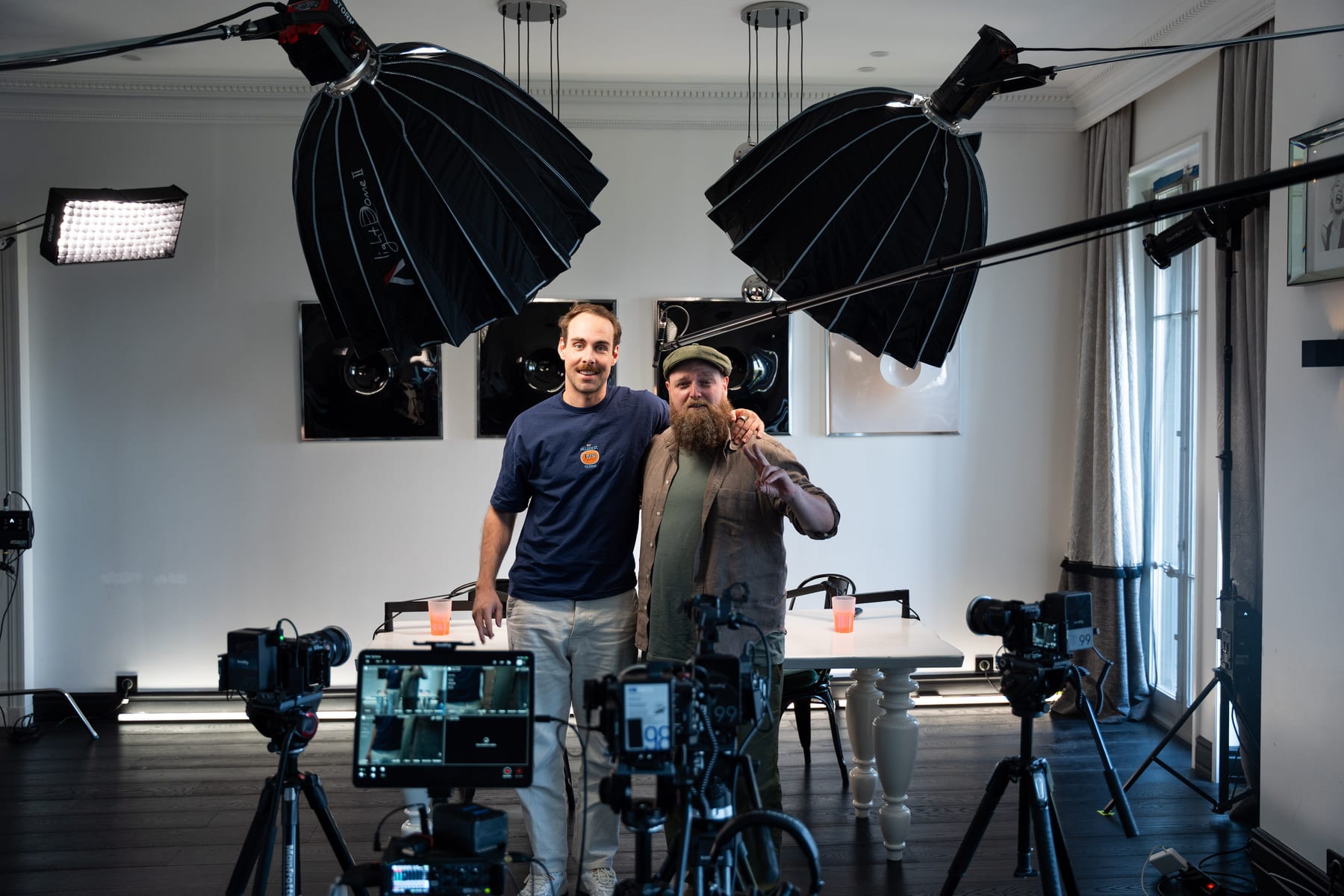 Wesley ter Haar and the host pose arm in arm in front of the podcast table under large softbox lights at Cannes Lions 2026