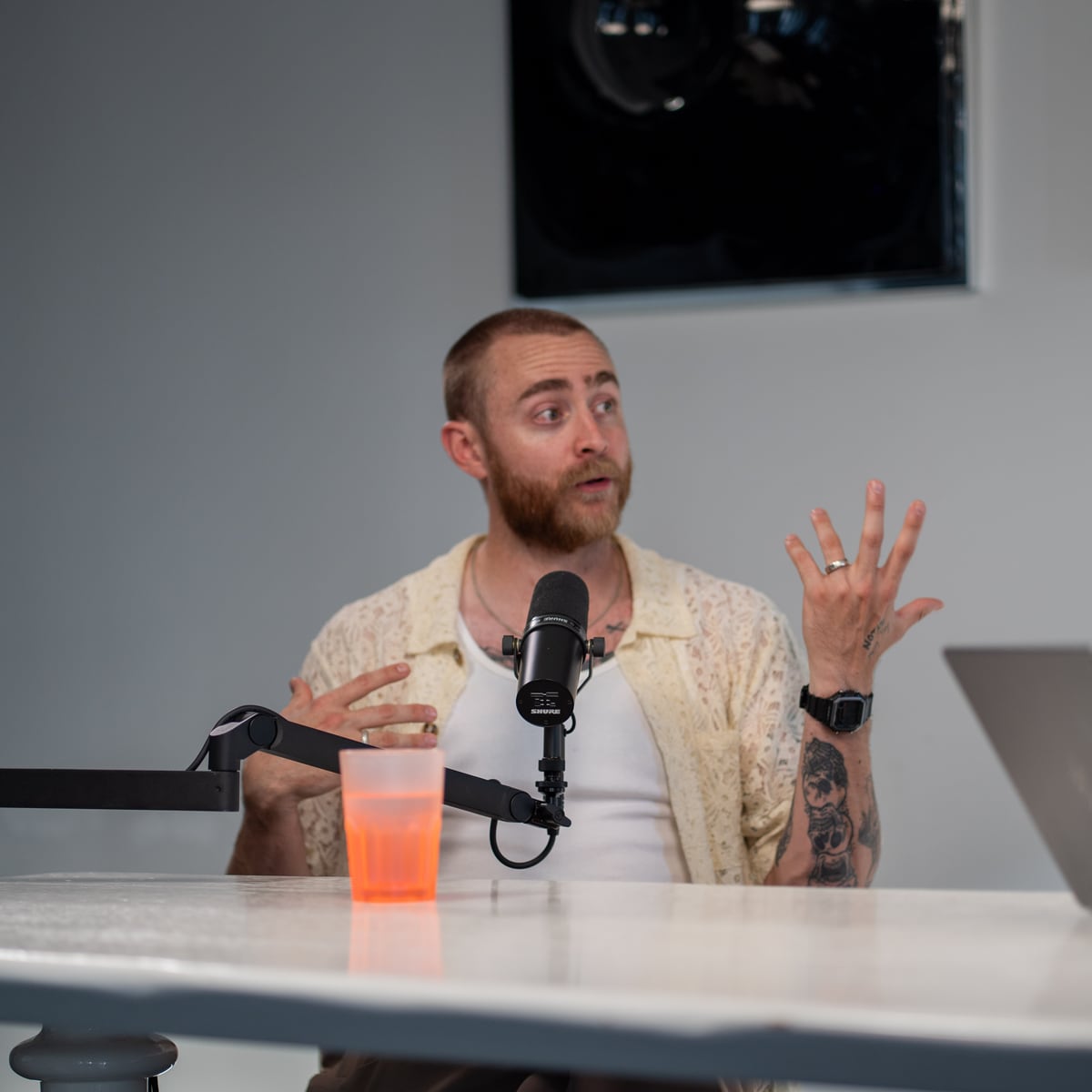 Brock Johnson talking with both hands raised at the microphone on the Conveo podcast set at Cannes Lions 2026