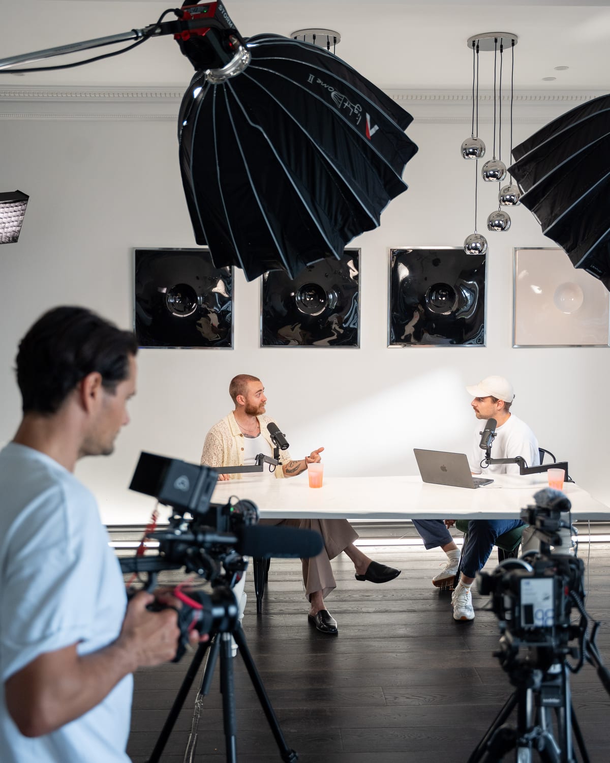 A camera operator films the conversation from behind a tripod on the Conveo podcast set at Cannes Lions 2026.