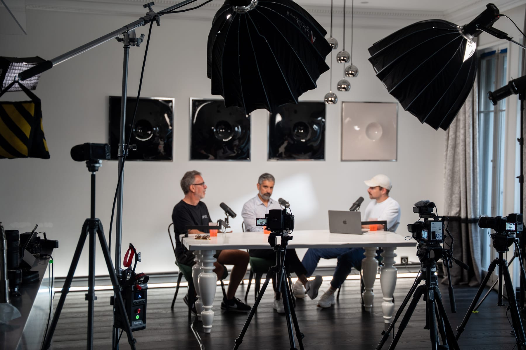 Wide view of the Conveo podcast studio with lights, umbrellas and camera rigs framing Barry Wacksman, Saneel Radia and the host at Cannes Lions 2026.