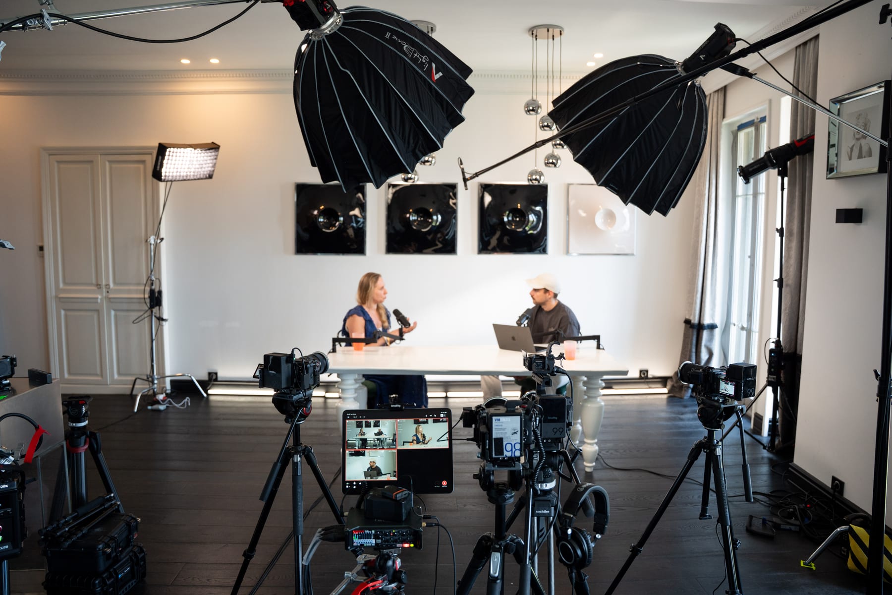 Wide view of the Conveo podcast studio with softbox lights, camera rigs and monitors in front of Karen Ehrlich and the host at their table at Cannes Lions 2026