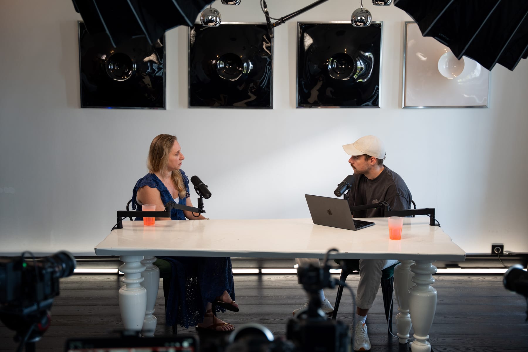 Karen Ehrlich and the host in conversation across the white podcast table on the Conveo set at Cannes Lions 2026