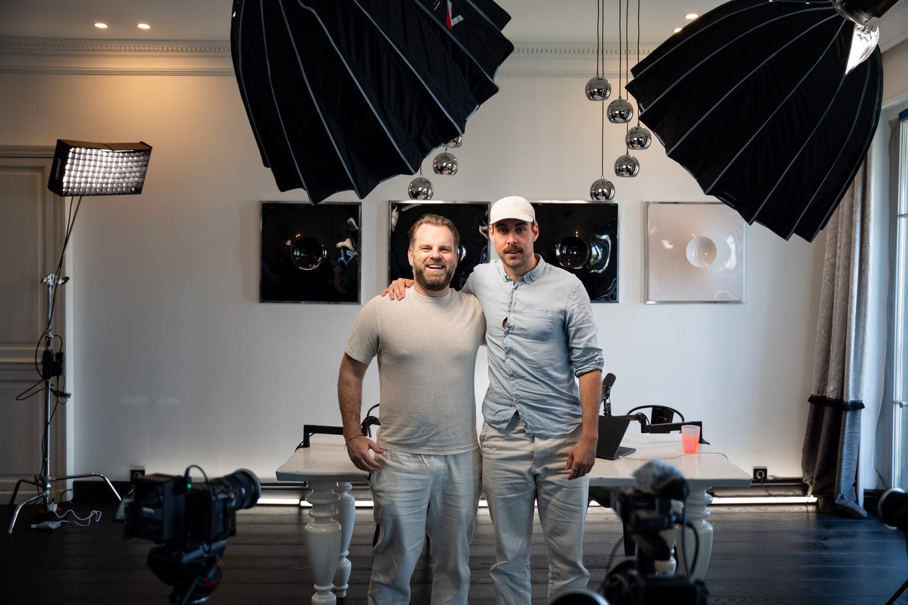 Matt Hammel and the host pose arm in arm on the podcast set under two large softboxes, with cameras in the foreground at Cannes Lions 2026