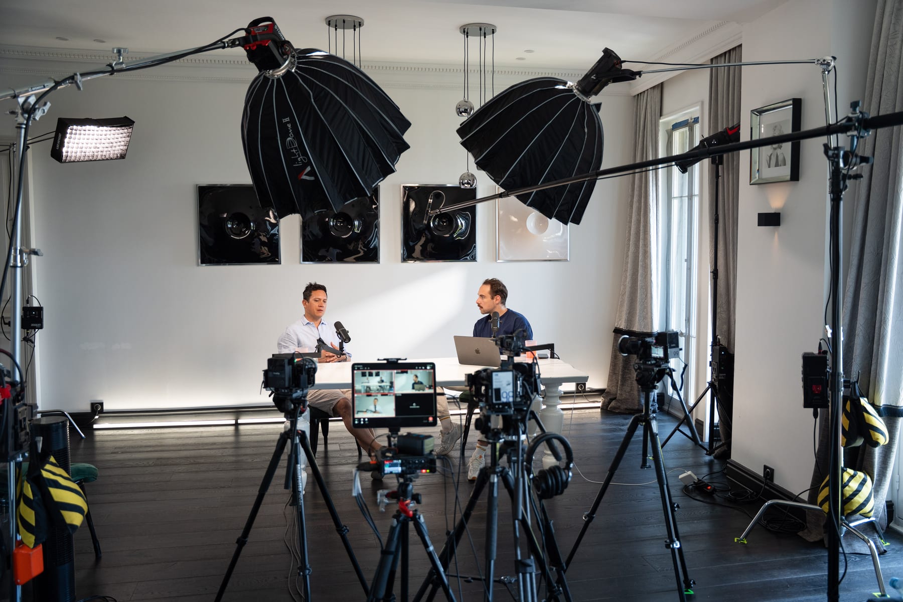 Wide view of the Conveo podcast studio with softbox lights, camera rigs and the guest and host seated at a white table at Cannes Lions 2026.