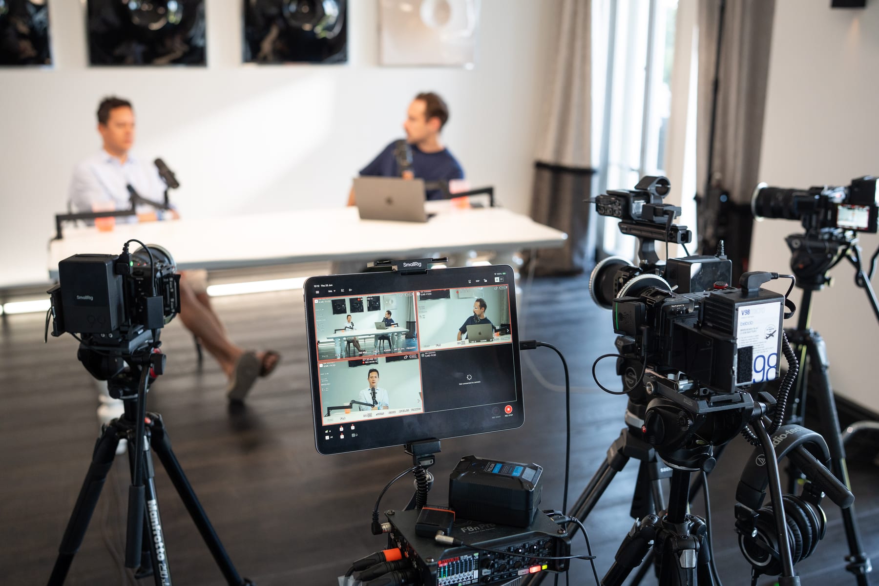 A camera monitor in the foreground shows the live feed of Miguel Avalos and the host seated at the podcast table at Cannes Lions 2026.