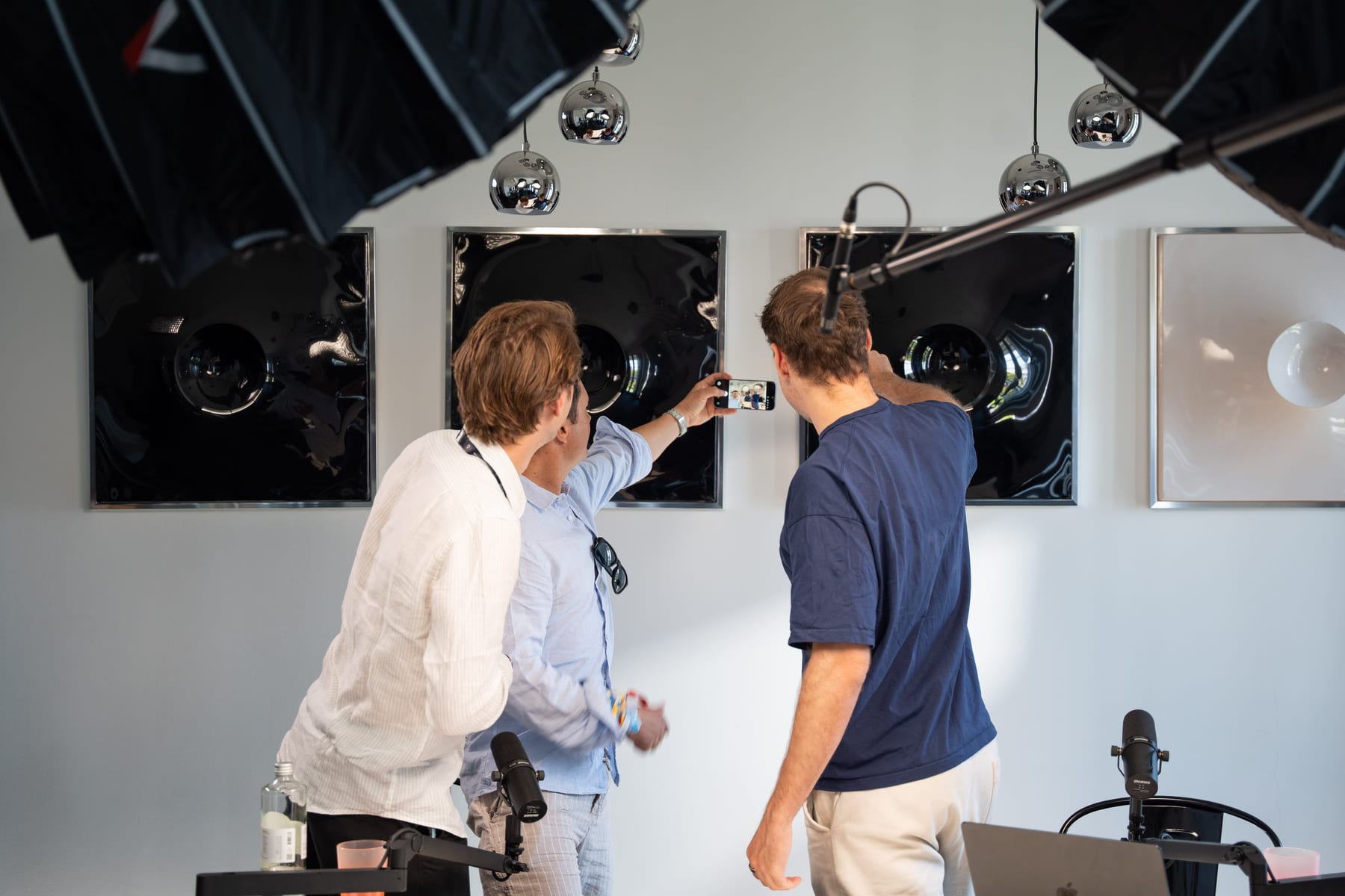 Miguel Avalos chats with two members of the Conveo team standing beside the podcast table between takes at Cannes Lions 2026.
