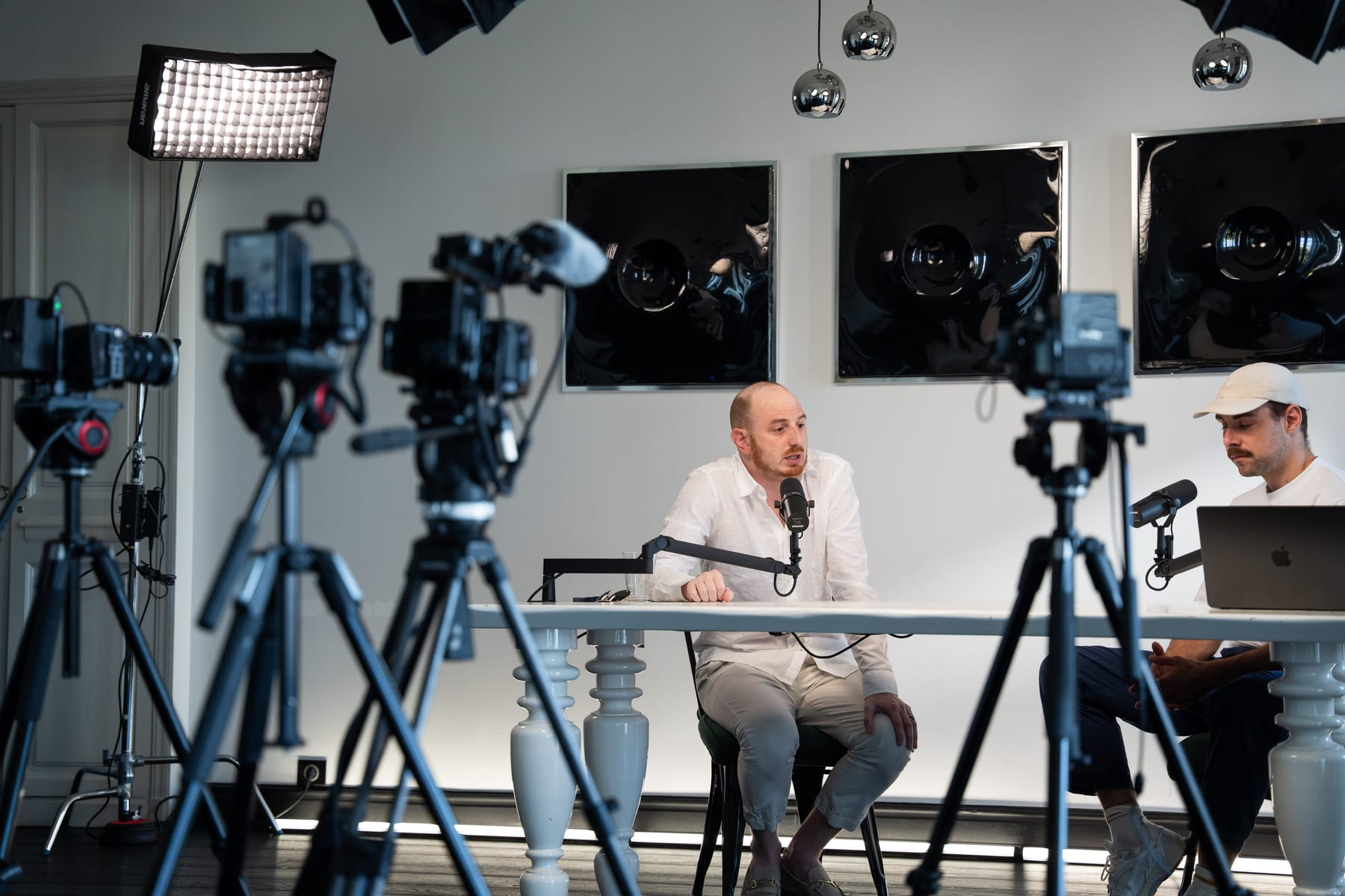 Wide view of the Conveo podcast set with several cameras on tripods filming Noah Plaue and the host at a white table at Cannes Lions 2026