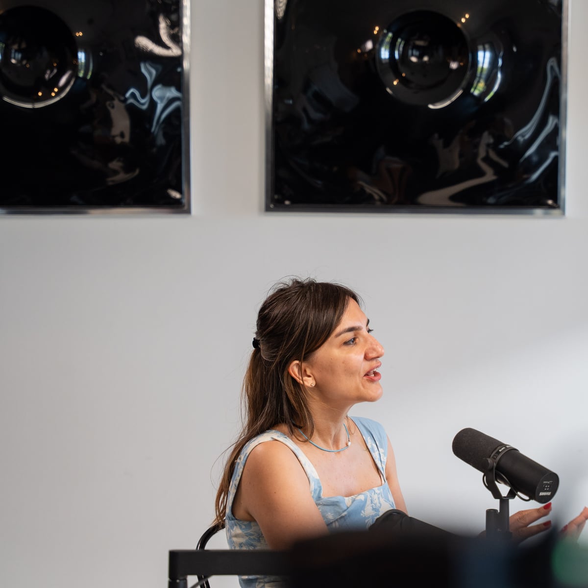 Özge Akcizmeci speaking into a microphone on the Conveo podcast set at Cannes Lions 2026