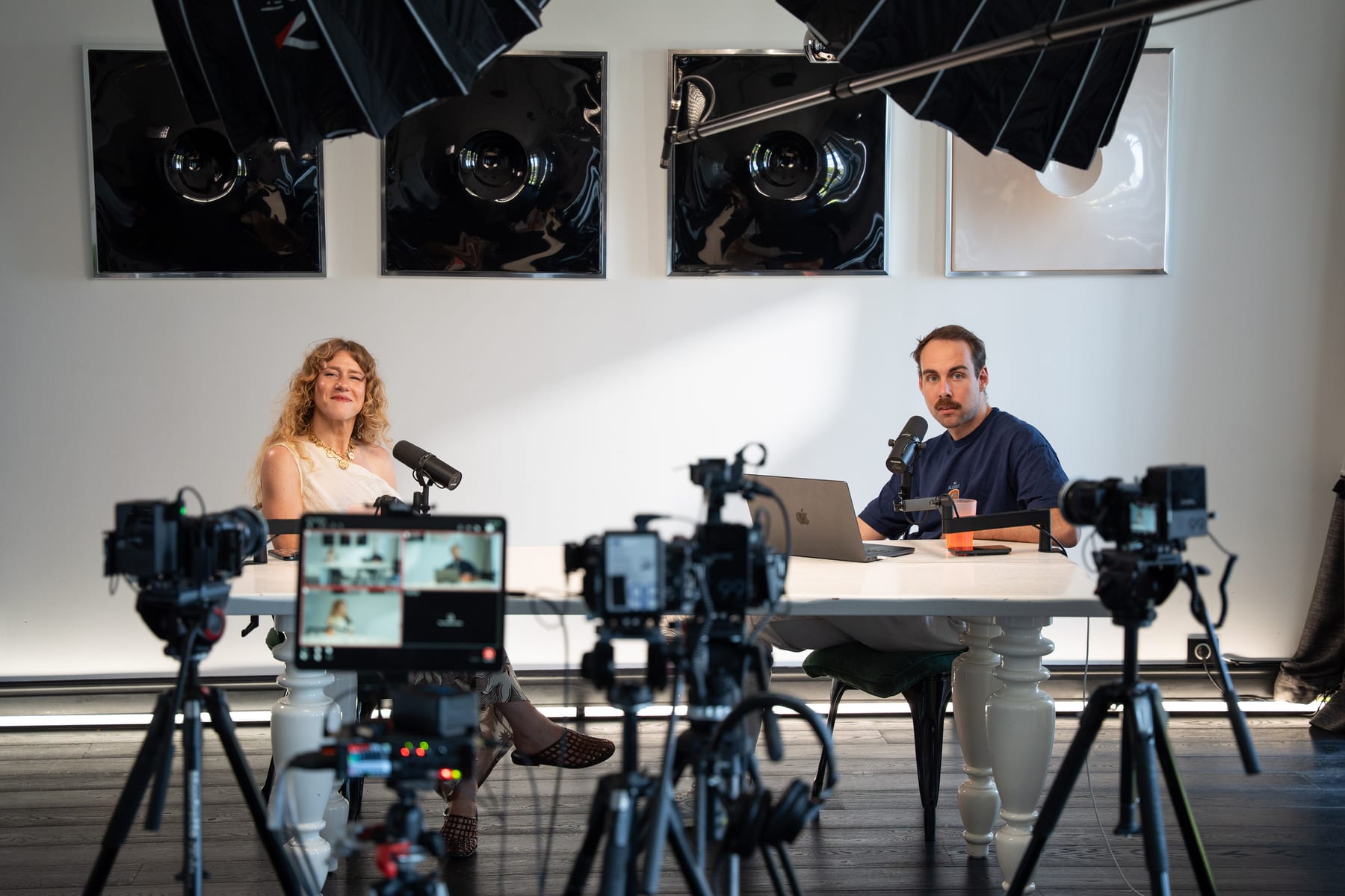 Wide view of Meredith Smith and the host recording the Conveo podcast behind a row of cameras and monitors at Cannes Lions 2026