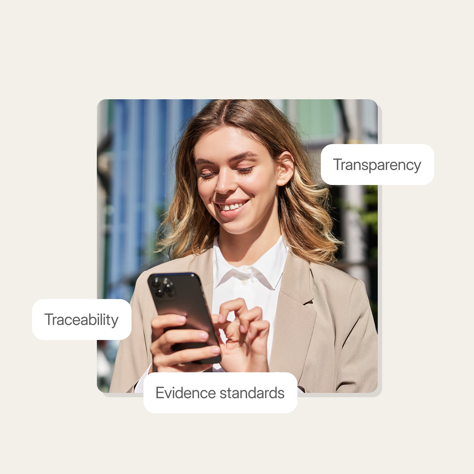 Woman in a beige blazer smiling at her phone, framed by labels reading traceability, transparency and evidence standards