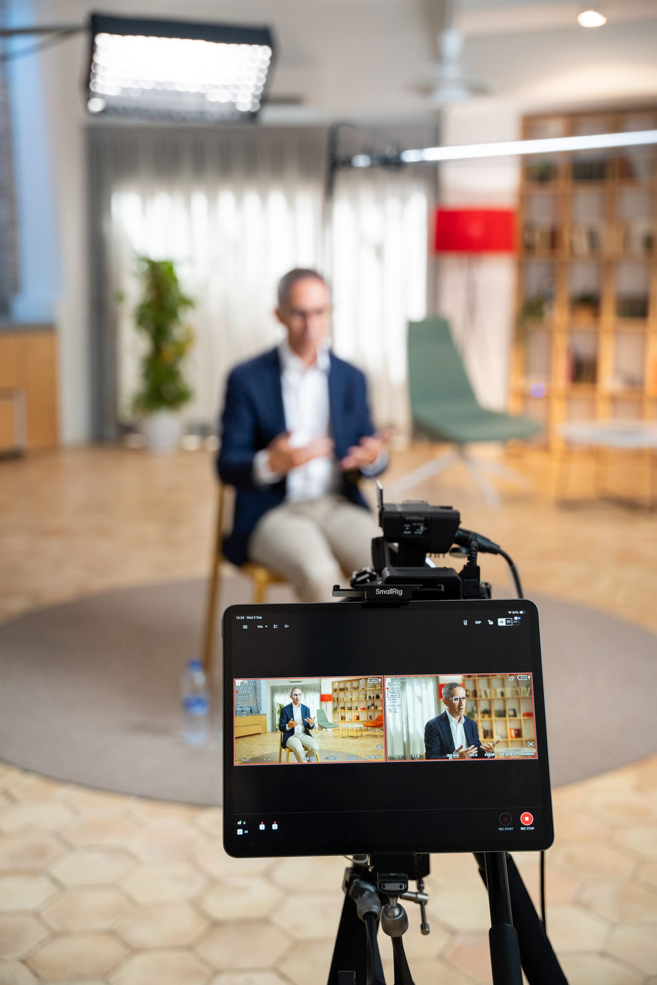 A camera monitor on a tripod in the foreground shows Pablo Pérez on screen while he sits in the interview chair behind it.